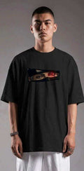 Oversized black anime T-shirt with Sharingan eye graphic, worn by male model